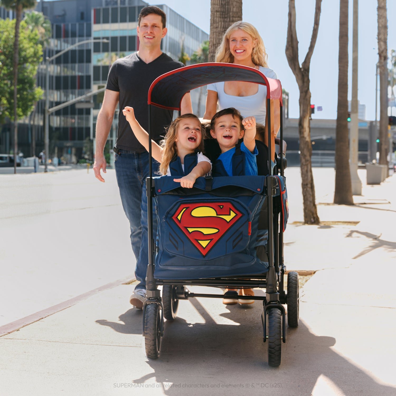 Family with two children in a Superman Wonderfold stroller wagon