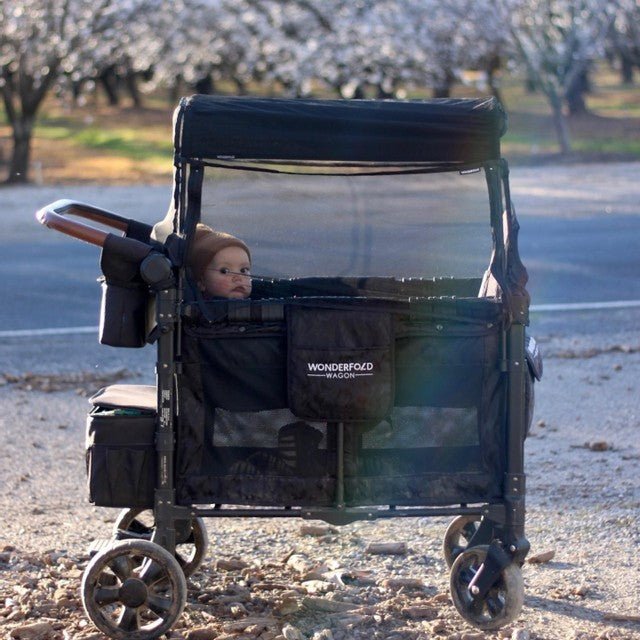 Baby in WonderFold stroller wagon enjoying a fall day outdoors